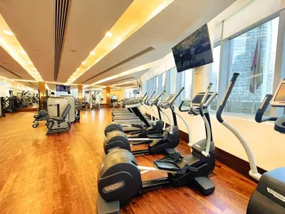 a gym with rows of treadmills and a flat screen tv at PVH - Dubai Mall Access 1BR - Emaar Fashion Avenue in Dubai