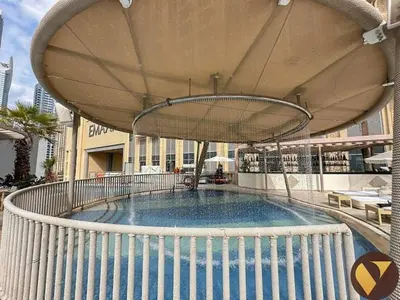 a swimming pool with an umbrella on top of a building at Vogue Marina JW Marriott with Direct Access to Marina Mall, Studio Apartment with Balcony and Marina Skyline View, Access to all Amenities in Dubai