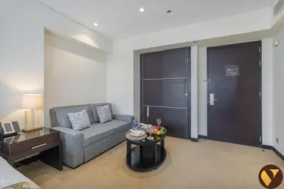 a living room with a couch and a table at Vogue Marina JW Marriott with Direct Access to Marina Mall, Studio Apartment with Balcony and Marina Skyline View, Access to all Amenities in Dubai