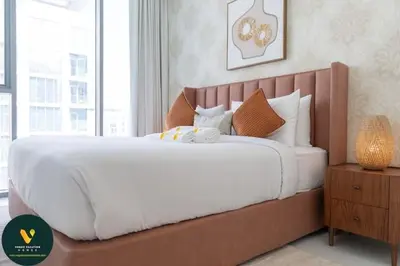 a large bed in a bedroom with a large window at Vogue Al Maktoum City, District One Residence, within a short drive from Downtown Burj Khalifa and Dubai Mall, Three Bedroom Apartment plus Kids Room with Large Balcony in Dubai