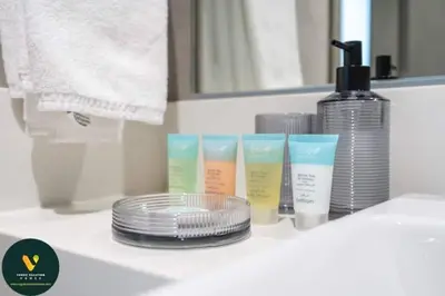 a bathroom counter with a group of moisturizers and a stack of plates at Vogue Al Maktoum City, District One Residence, within a short drive from Downtown Burj Khalifa and Dubai Mall, Three Bedroom Apartment plus Kids Room with Large Balcony in Dubai