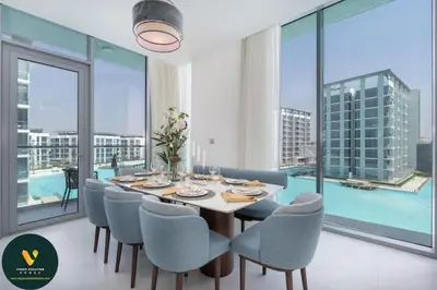 a dining room with a table and chairs and a large window at Vogue Al Maktoum City, District One Residence, within a short drive from Downtown Burj Khalifa and Dubai Mall, Three Bedroom Apartment plus Kids Room with Large Balcony in Dubai