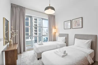 a hotel room with two beds and a window at Boema Apartments- Luxury with Burj Khalifa View in Dubai