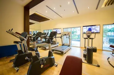 a gym with treadmills and ellipticals in a room at Boema Apartments- Luxury with Burj Khalifa View in Dubai