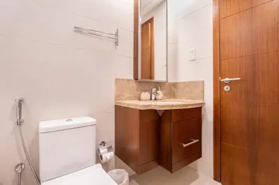 a bathroom with a sink and a toilet and a mirror at Boema Apartments- Luxury with Burj Khalifa View in Dubai