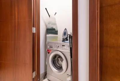 a washing machine in a corner of a room at Boema Apartments- Luxury with Burj Khalifa View in Dubai