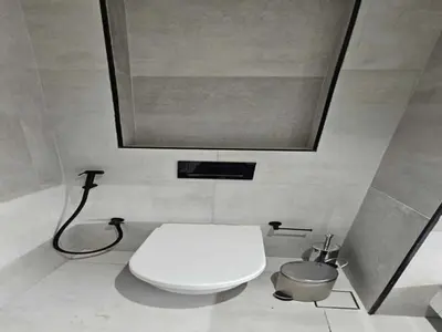 a bathroom with a white toilet and a mirror at Beautiful Studio in Jumeirah Village Circle in Dubai