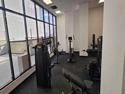 a gym with treadmills and exercise equipment in a building at Beautiful Studio in Jumeirah Village Circle in Dubai