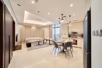 a kitchen and living room with a table and chairs at FAM Living Stylish 1BR in Nobles Tower Near Downtown in Dubai