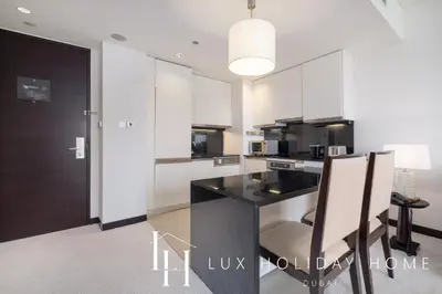 a kitchen with a black counter and white cabinets at LUX The JW Marina Suite 4 in Dubai