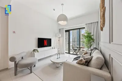 a living room with a couch and a tv at The Ivory Crown 1BR Downtown Dubai in Dubai