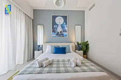 a bedroom with a large bed with blue pillows at The Ivory Crown 1BR Downtown Dubai in Dubai