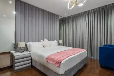 a bedroom with a large bed and a blue chair at 83rd Floor Luxurious Penthouse Full Sea View 6 BHK in Dubai