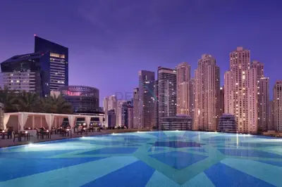 a large swimming pool in front of a city skyline at Luxury 1BR with Breathtaking Dubai Water Canal Views, Just Beside Dubai Marina Mall and Tram, Near JBR Beach, The Address Residences, Dubai Marina by Deluxe Holiday Homes in Dubai