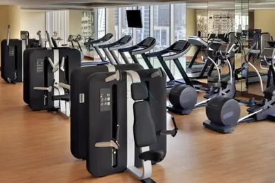 a gym with rows of treadmills and exercise equipment at Luxury 1BR with Breathtaking Dubai Water Canal Views, Just Beside Dubai Marina Mall and Tram, Near JBR Beach, The Address Residences, Dubai Marina by Deluxe Holiday Homes in Dubai