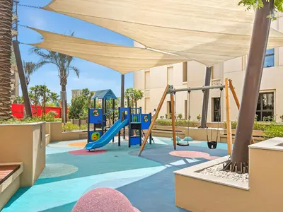 a playground with a slide and swings at Stylish 1BR with Balcony and Burj AlArab View in Dubai