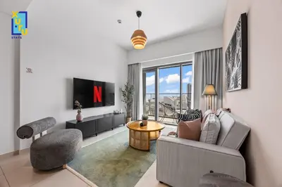 a living room with a couch and a tv at Celestial & Curated 1BR Downtown Dubai in Dubai