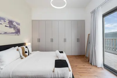 a bedroom with a white bed and a large window at Elegant 2Bhk Panorama Apartment in Dubai