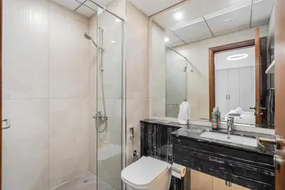 a bathroom with a shower and a toilet and a sink at Elegant 2Bhk Panorama Apartment in Dubai
