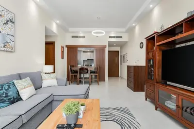 a living room with a couch and a flat screen tv at Elegant 2Bhk Panorama Apartment in Dubai