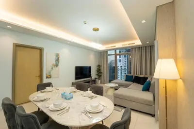 a living room with a table and a couch at Paramount Hotel Midtown 2BR Apartment With Burj Khalifa View in Dubai