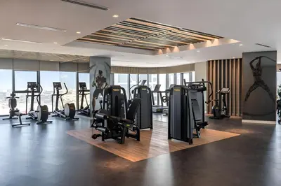 a gym with rows of treadmills and exercise bikes at Paramount Hotel Midtown 2BR Apartment With Burj Khalifa View in Dubai