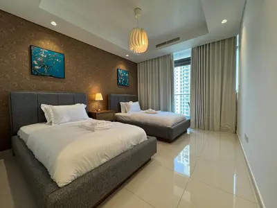 a bedroom with two beds and a couch at Paramount Hotel Midtown 2BR Apartment With Burj Khalifa View in Dubai