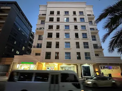 a white van parked in front of a tall building at Affordable Hostel in Al Barsha 1 Near Mall of Emirates Metro in Dubai