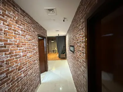 a hallway with a brick wall and a doorway at Affordable Hostel in Al Barsha 1 Near Mall of Emirates Metro in Dubai