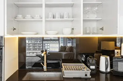 a kitchen with a sink and a living room at The Pad luxury 1BR with full Canal View in Dubai