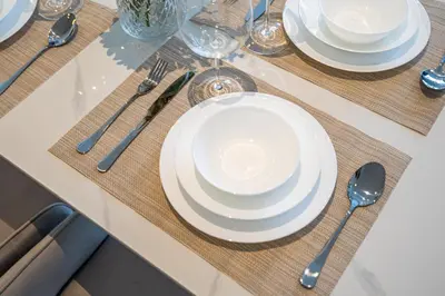 a table with white plates and silverware on it at The Pad luxury 1BR with full Canal View in Dubai