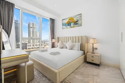 a bedroom with a bed and a desk and windows at The Pad luxury 1BR with full Canal View in Dubai