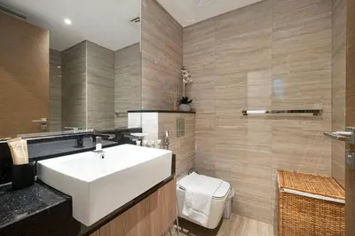 a bathroom with a white sink and a toilet at Moon Stays - Canal View- 2BR Missoni Stay in Dubai