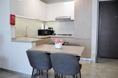 a kitchen with a table with chairs and a sink at Cozy spacious Modern 1 bedroom Apartment in Dubai