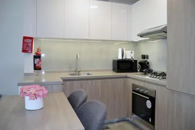 a kitchen with a table and chairs and a sink at Cozy spacious Modern 1 bedroom Apartment in Dubai