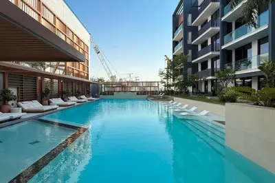 a large swimming pool in a building with white chairs at New Studio in JVC - Hamilton House at 5th floor in Dubai