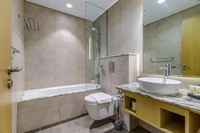 a bathroom with a sink and a toilet and a tub at Paramount Towers & Residences - 1 Bedroom Apartment - Allsopp & Allsopp in Dubai