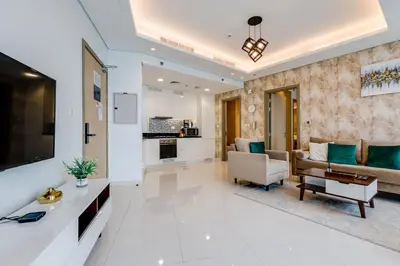 a living room with a couch and a tv at Paramount Midtown - 1 Bedroom Apartment - Allsopp & Allsopp in Dubai