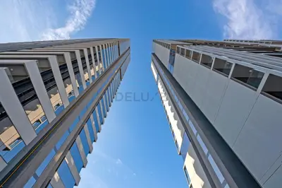 two tall buildings looking up at the sky at Stay Near the Park with Easy Exit from JVC, Just Minutes to Dubai Marina and Palm Jumeirah - Bloom Towers A, JVC by Deluxe Holiday Homes in Dubai