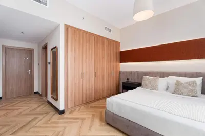 a bedroom with a large bed and wooden cabinets at Spacious 2BR Dubai Marina & City Views in Dubai
