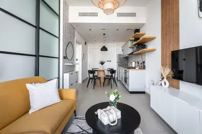 a living room with a couch and a table at Stylish 1BR Dubai Hills Walk to Park & Mall in Dubai