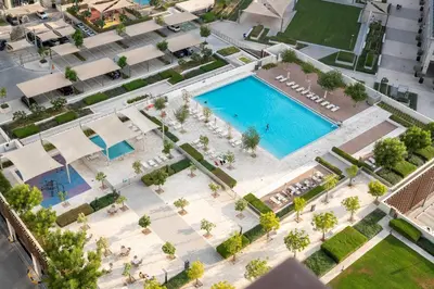 an overhead view of a swimming pool in a city at Stylish 1BR Dubai Hills Walk to Park & Mall in Dubai