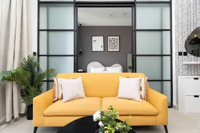 a living room with a yellow couch at Stylish 1BR Dubai Hills Walk to Park & Mall in Dubai