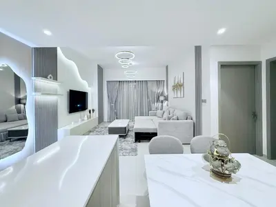 a white living room with a couch and a living room at Balcony Bliss 1BR with City View Pool & Gym in Dubai