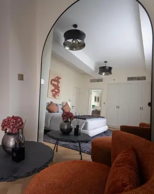 a living room with a couch and a large mirror at Elegant 2-Bedroom Apartment with Breathtaking Cityscape in Dubai