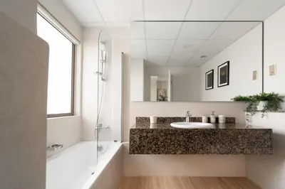 a bathroom with a sink and a tub and a mirror at Elegant 2-Bedroom Apartment with Breathtaking Cityscape in Dubai