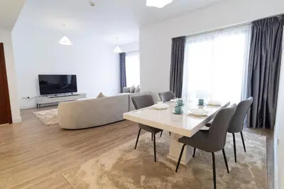 a living room with a table and chairs and a couch at Happy Season - Luxury Upgraded 2BR Rimal JBR in Dubai