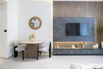 a living room with a table and a tv at PNB Living - Luxury Studio with Canal Views - Trillionaire Residences, Business Bay in Dubai