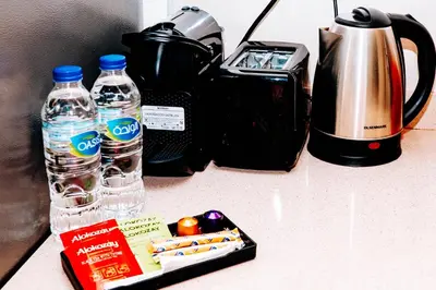 a table with a camera and bottles of water and snacks at Skyline Views, Fully Equipped Studio with Balcony, Near Burj Khalifa in Dubai