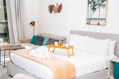 a living room with a bed and a couch at Skyline Views, Fully Equipped Studio with Balcony, Near Burj Khalifa in Dubai